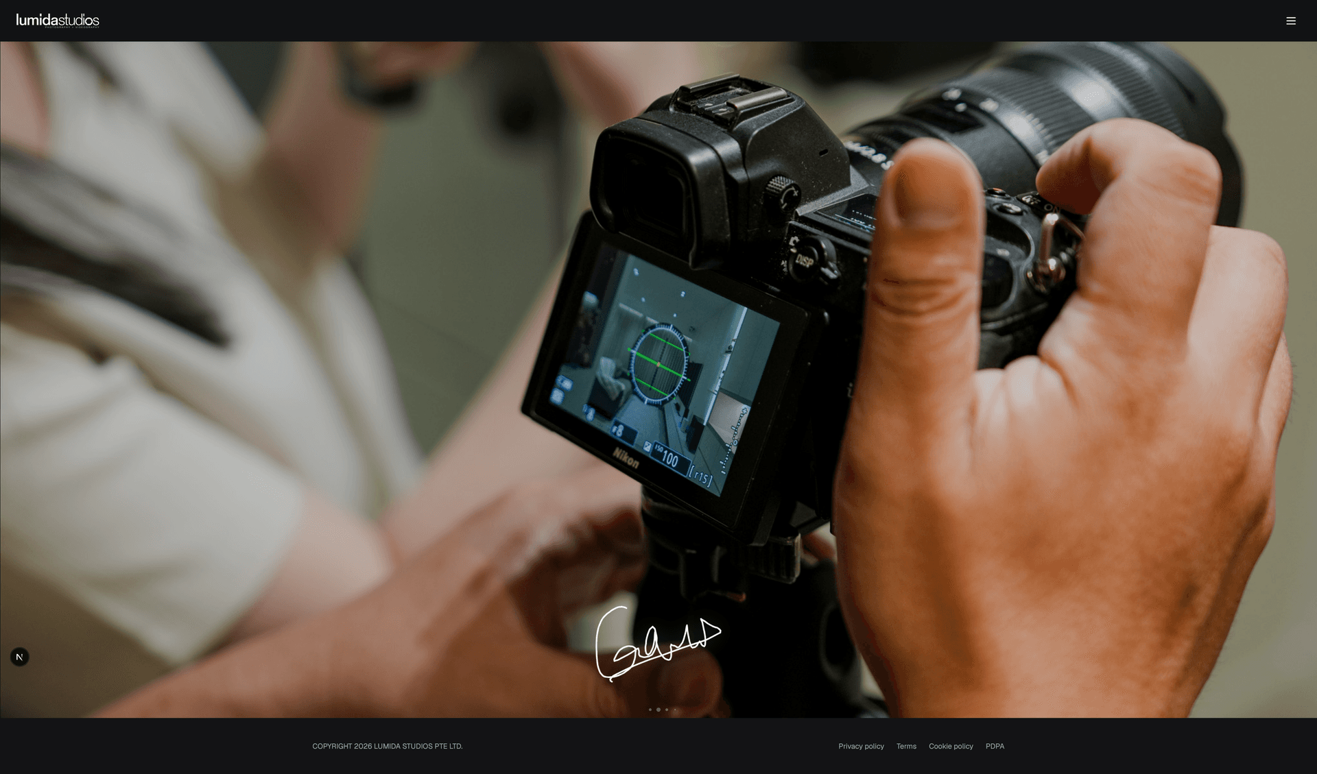 Lumida Studios website with a full-width close-up of a photographer using a camera