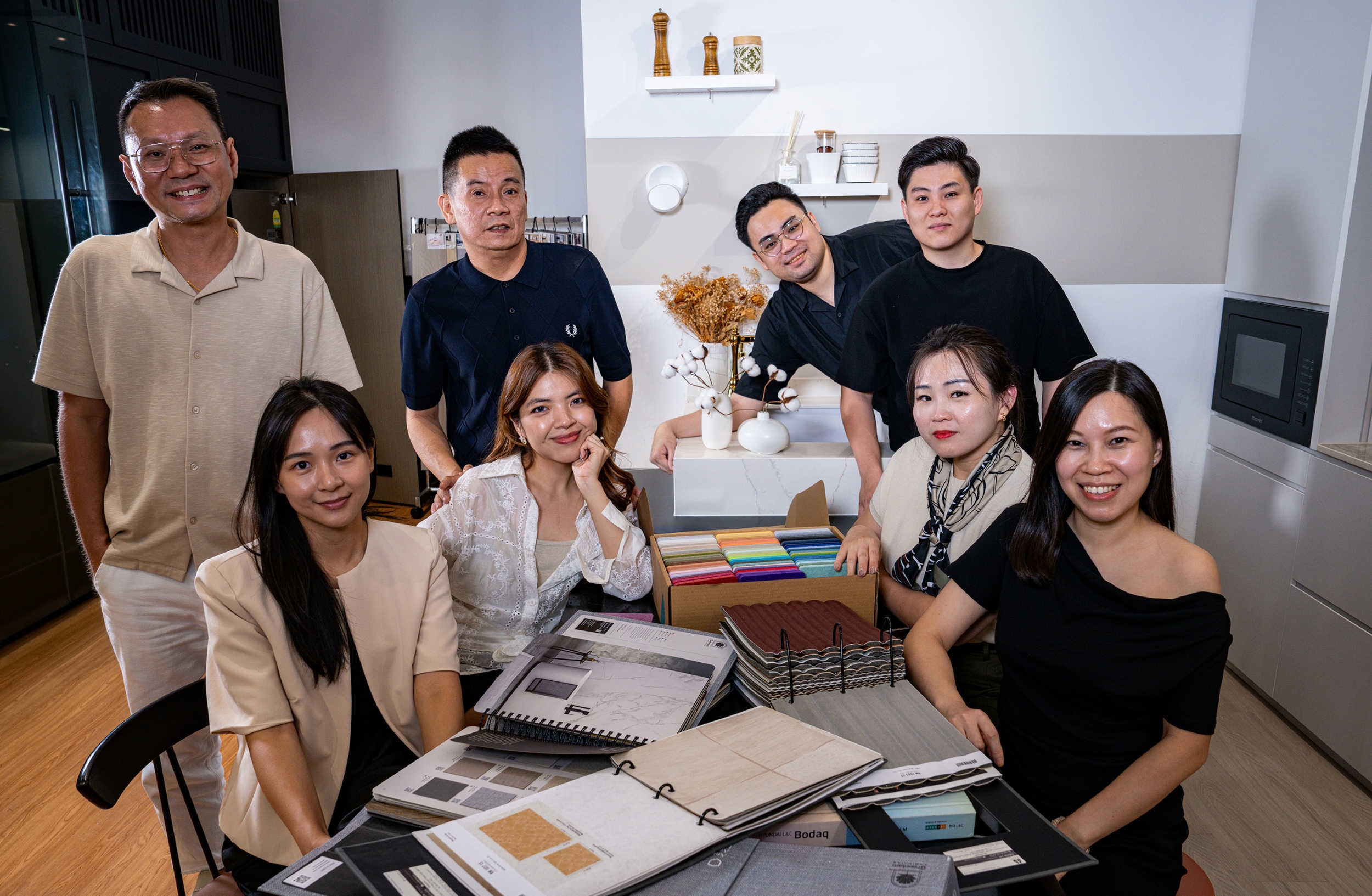 The Dreamer Home team gathered around material boards and finish samples