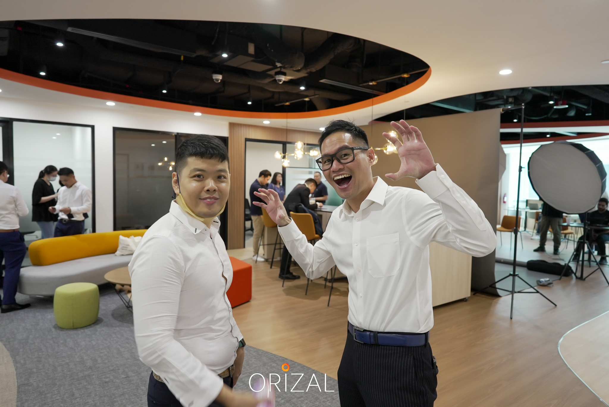 Two Orizal advisors posing playfully beside the photoshoot setup