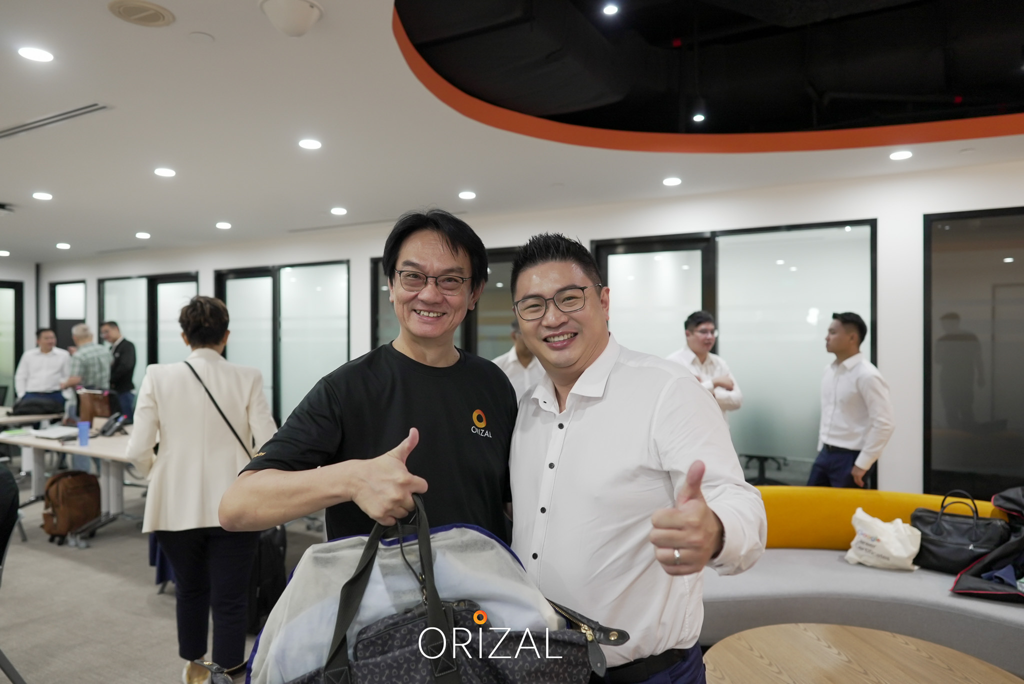 Two Orizal advisors smiling and giving thumbs up in the office