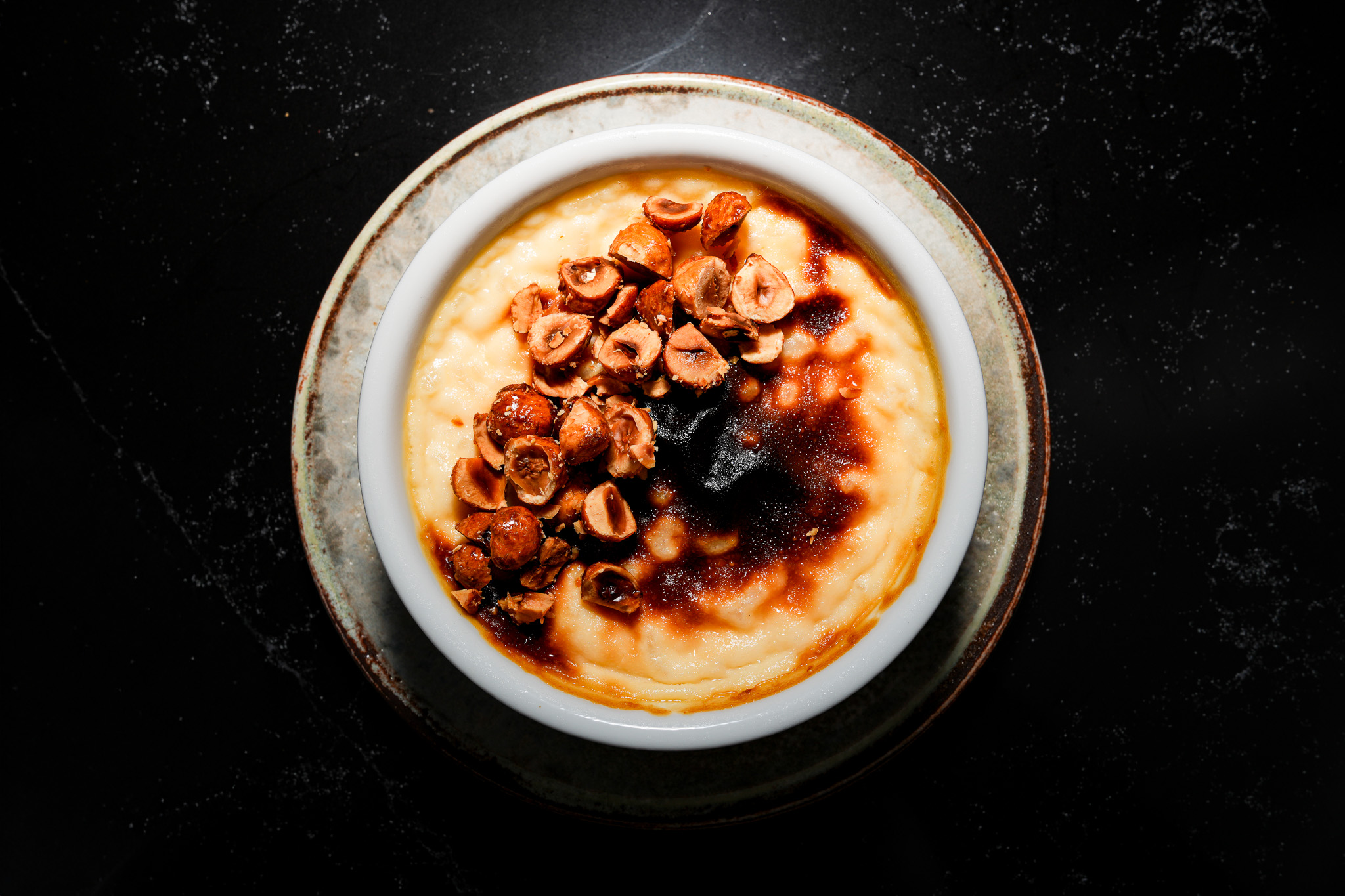 Baked pudding topped with toasted hazelnuts, viewed from above