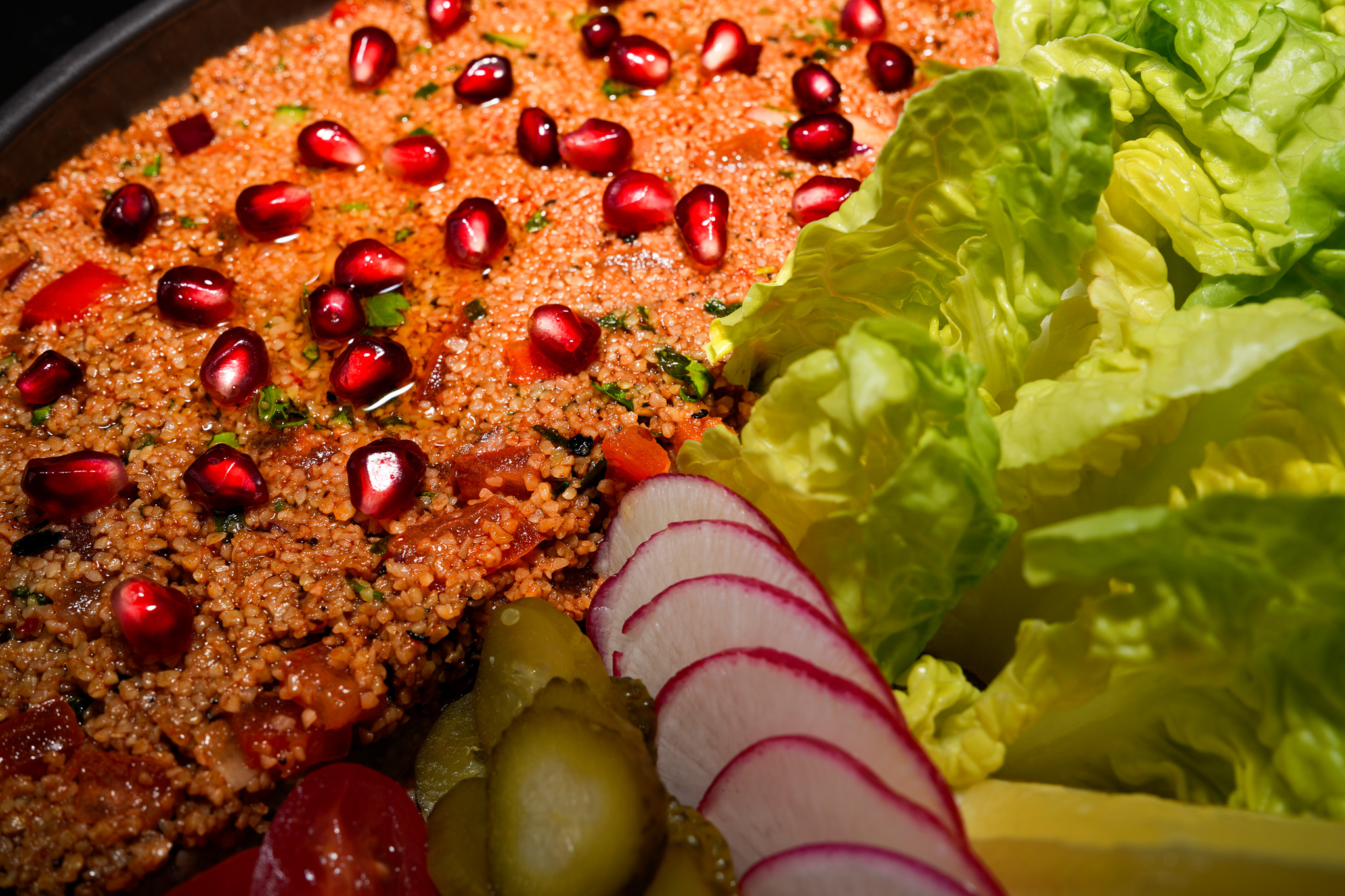 Bulgur salad with pomegranate, lettuce, radish, and pickles