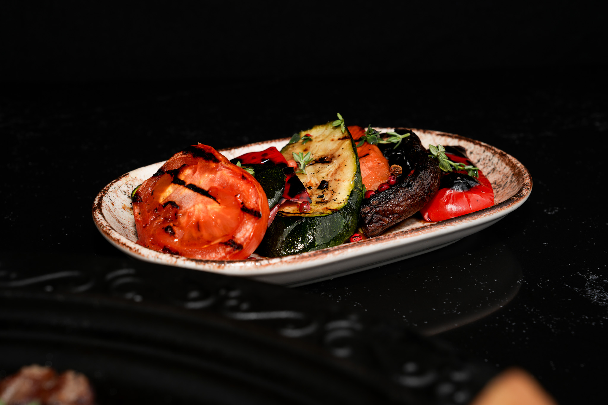A side plate of grilled tomatoes, courgettes, aubergines, and peppers