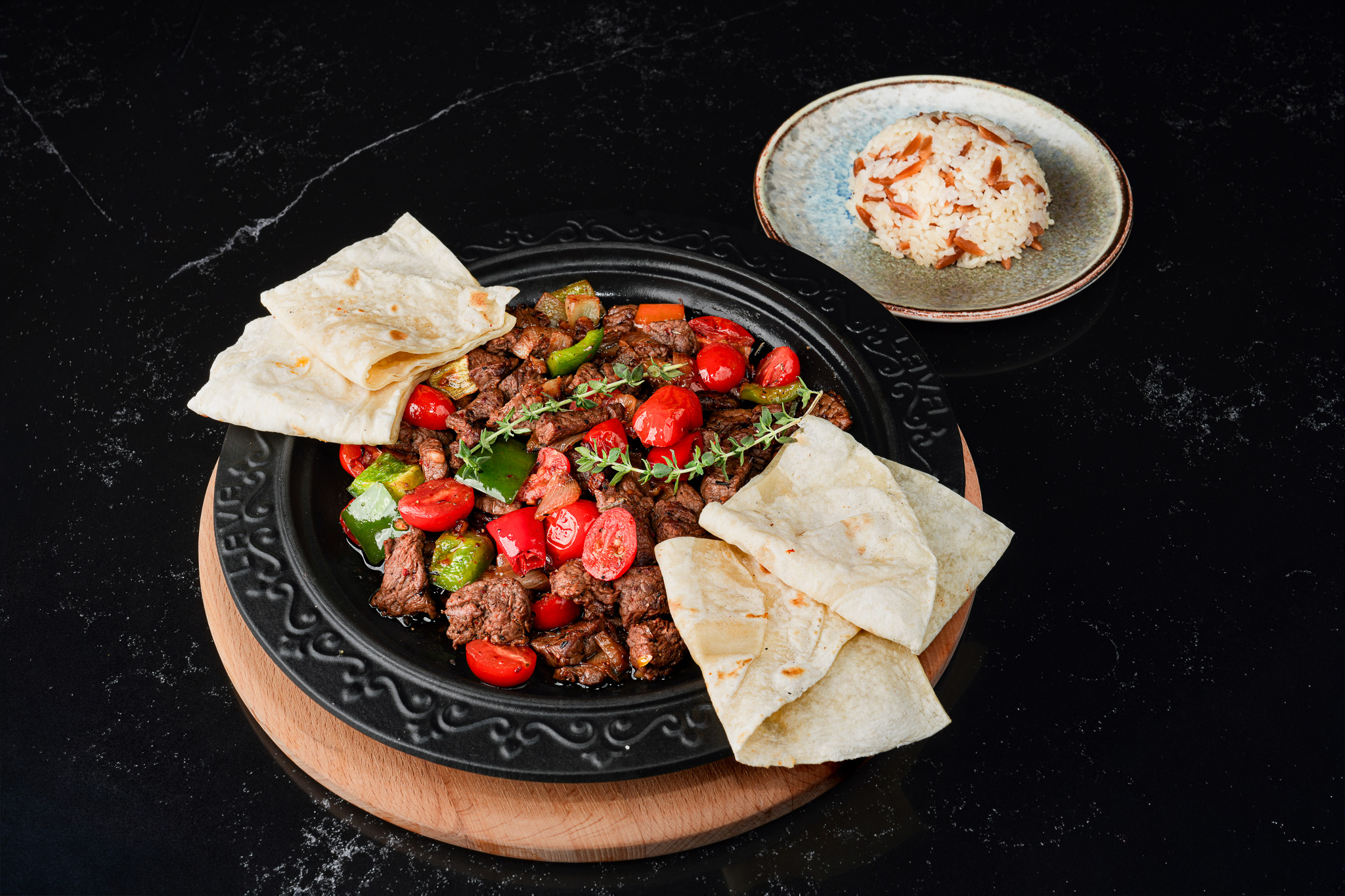 Meat and pepper skillet served with flatbread and rice