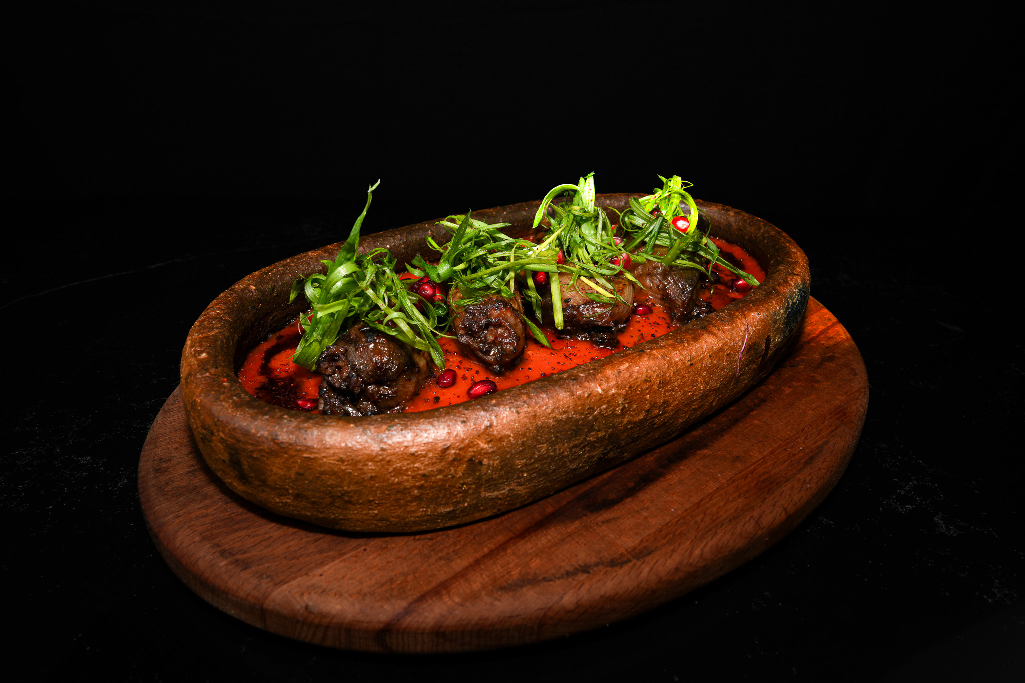 Meatballs in tomato sauce topped with sliced green herbs