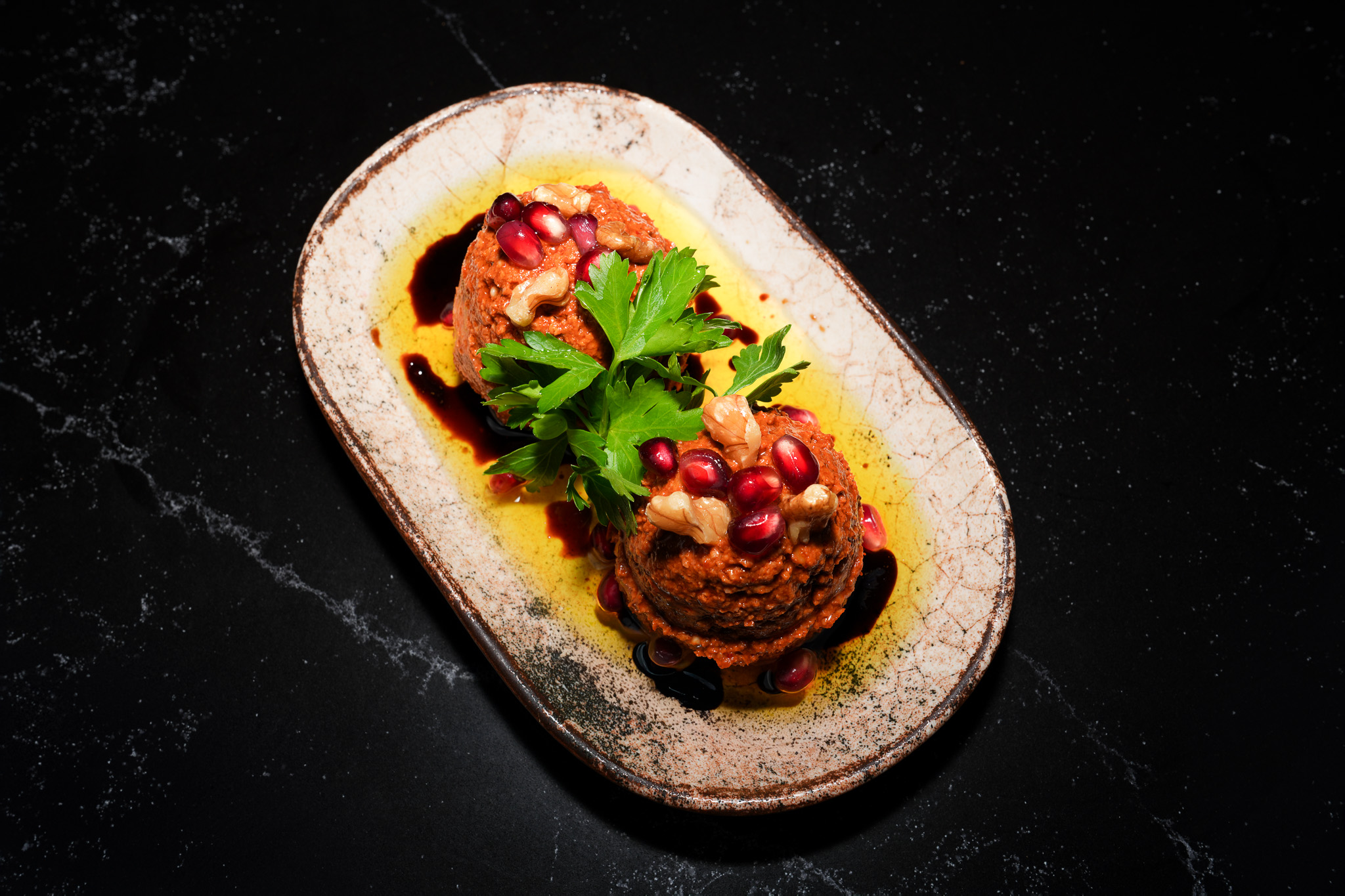 Two scoops of mezze topped with parsley and pomegranate