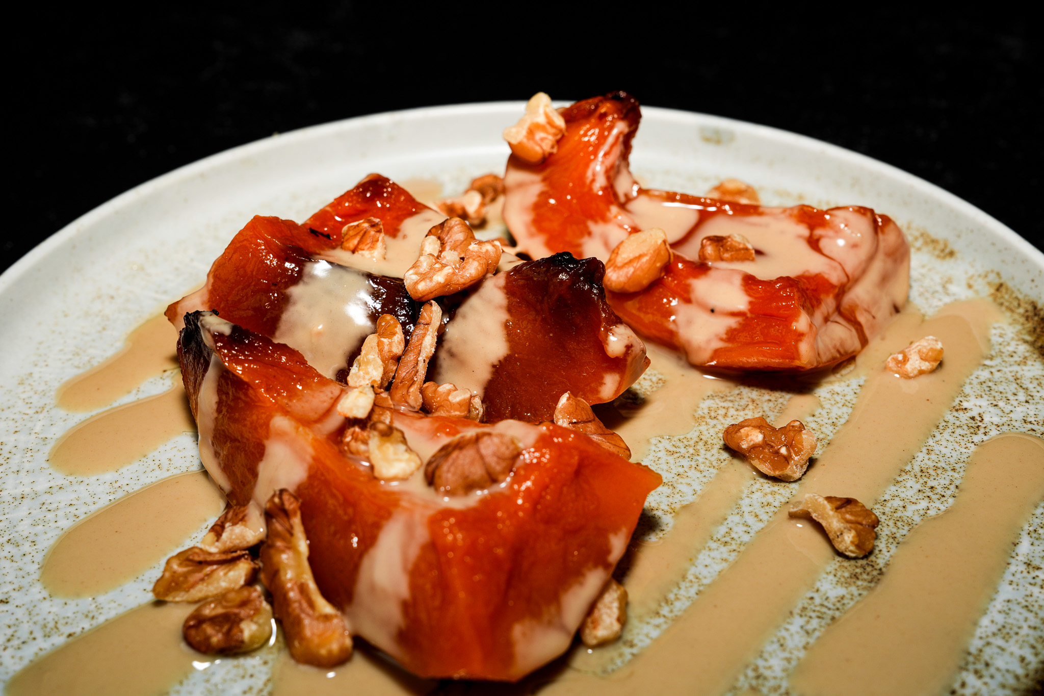 Close-up of pumpkin dessert topped with tahini and nuts