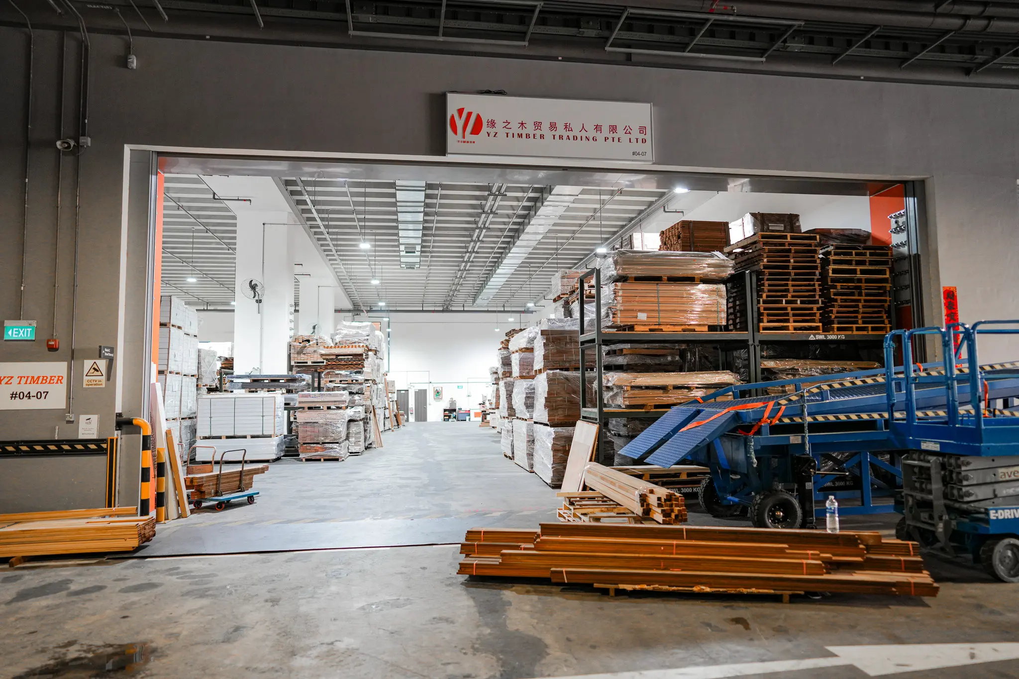 Entrance to the YZ Timber warehouse with the company sign above rows of timber stock