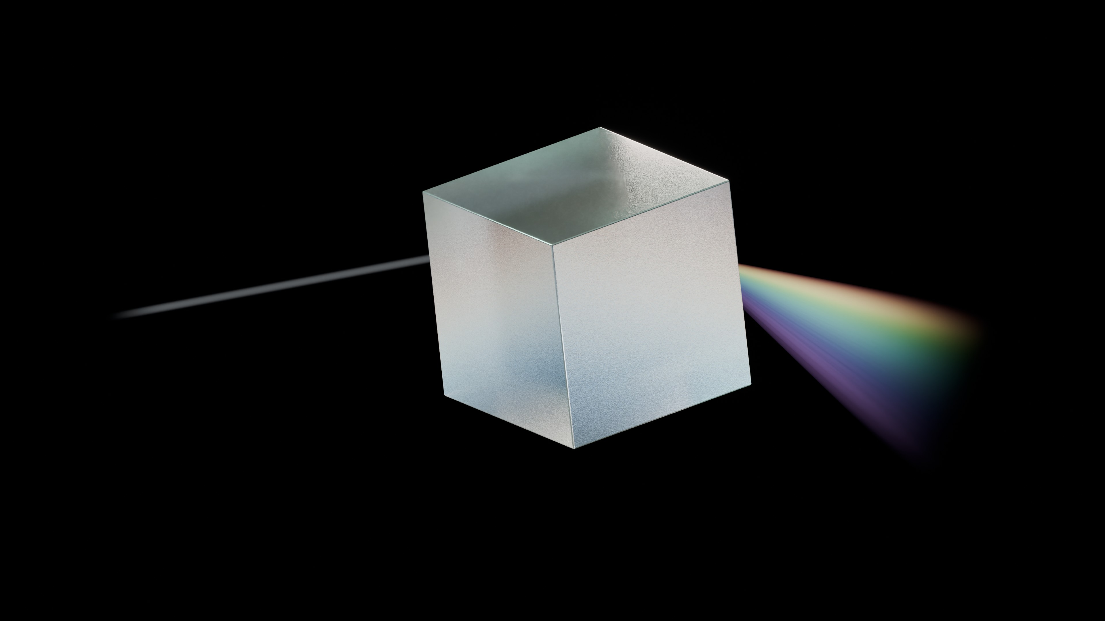 A glass prism separates a beam of light into a spectrum of colours.
