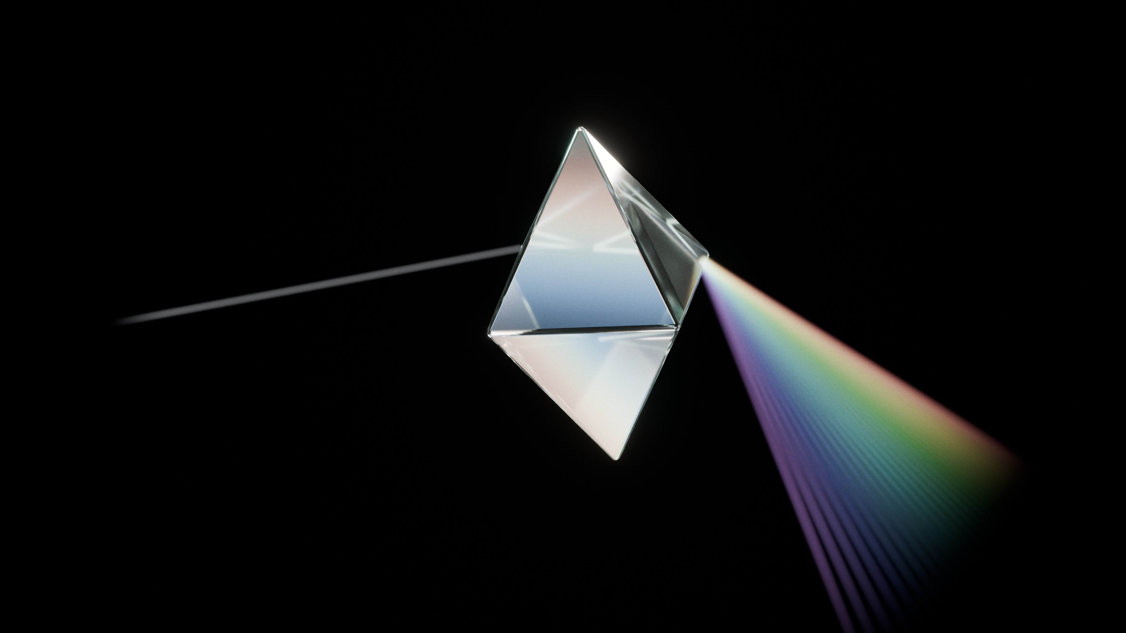 A glass prism separates a beam of light into a spectrum of colours.